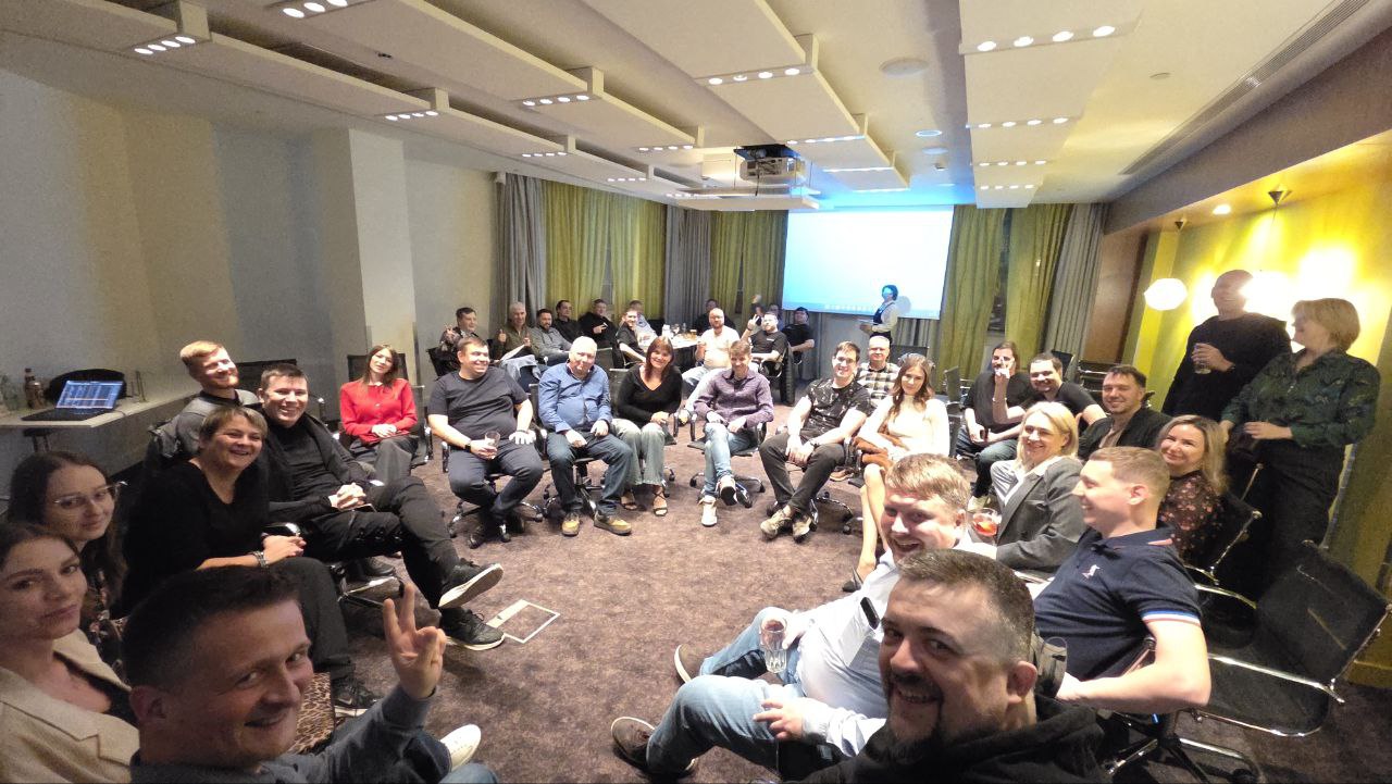 Участники pre-party 2025 сидят в кругу в зале отеля и улыбаются в камеру
